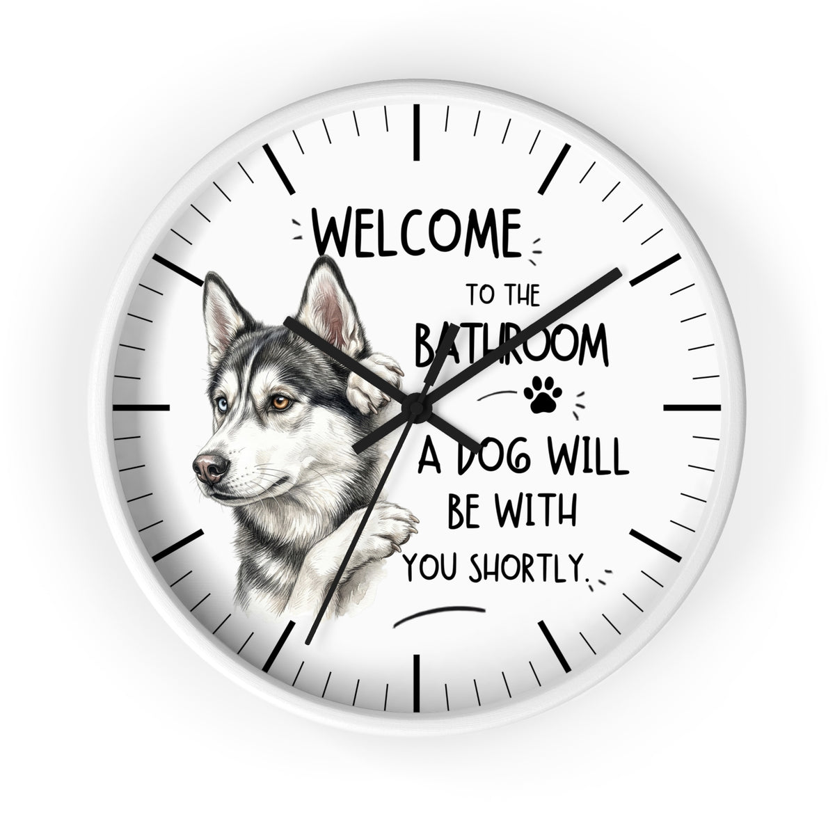 A round wall clock with a white face, black hands, black hour markers, and a printed husky illustration alongside the text 'WELCOME TO THE BATHROOM A DOG WILL BE WITH YOU SHORTLY.' on a light gray background.