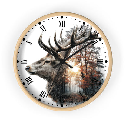 A round wall clock with a light wood frame and a white face featuring a large deer head over a forest scene with Roman numerals and black hands.