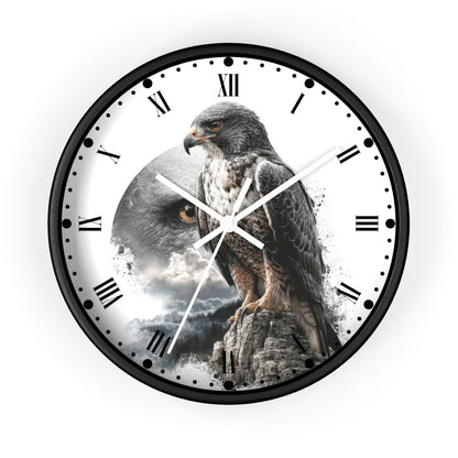 A round wall clock with a black frame and a white face featuring a large hawk perched on a rock with a cloudy sky behind it. The clock uses Roman numerals for hour markers and has white hands.