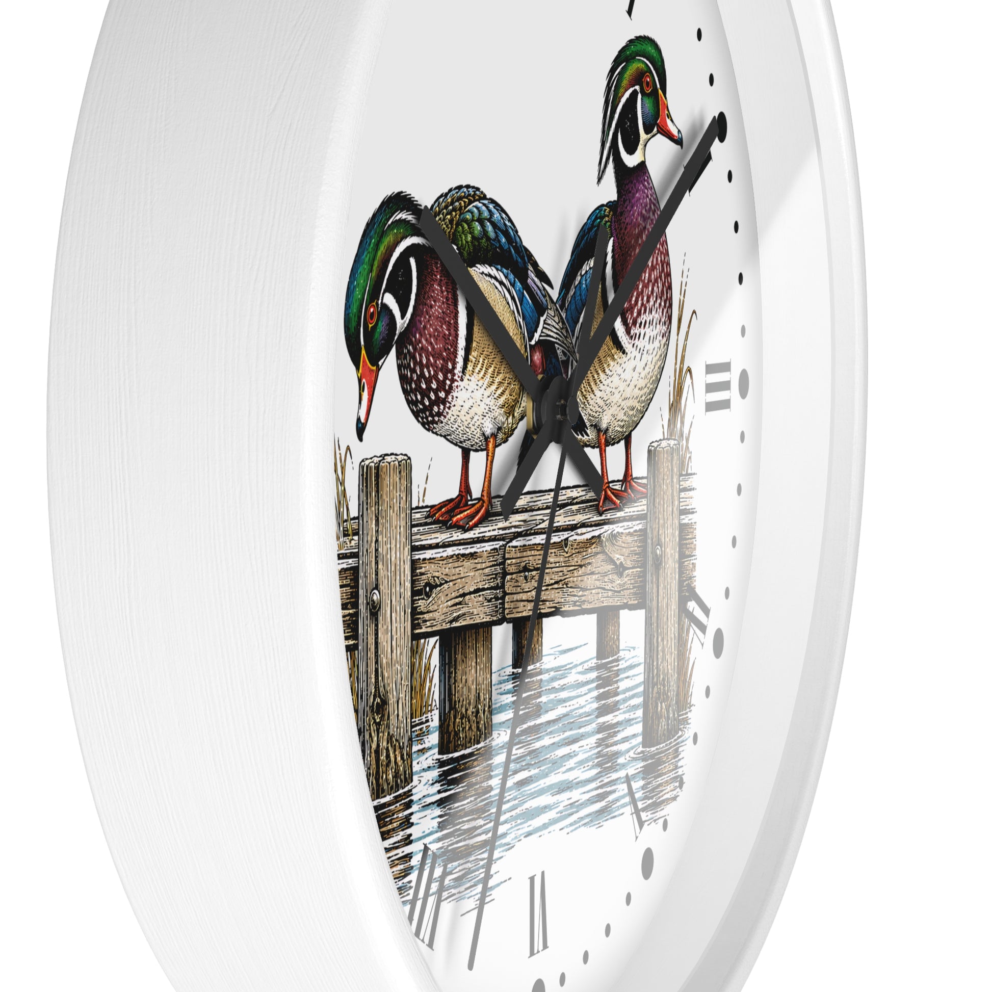 A white round wall clock with a printed illustration of three wood ducks standing on a wooden dock over water, with black Roman numerals and black hands.