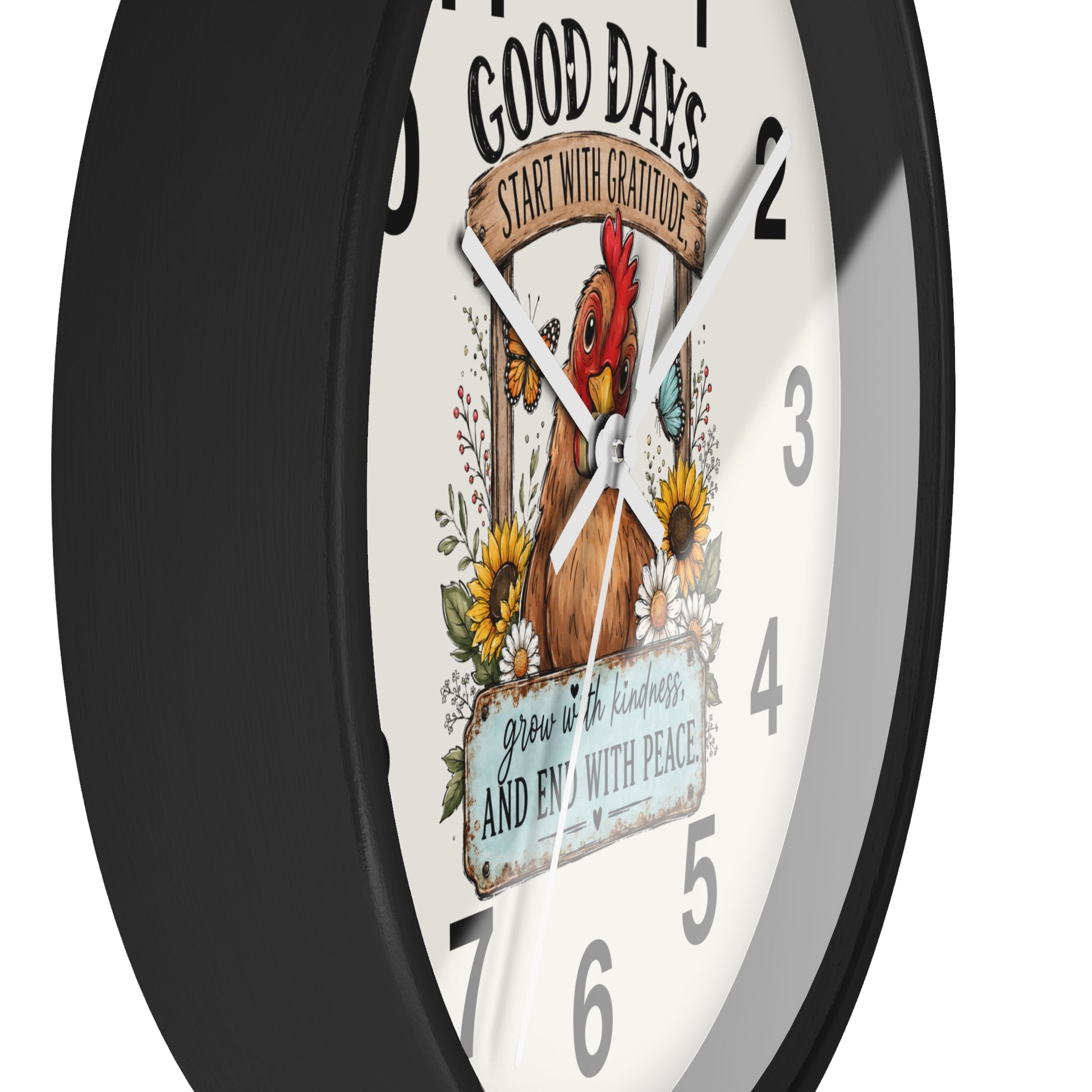 A round wall clock with a black frame and a white face featuring a rooster illustration, floral details, and the text 'GOOD DAYS START WITH GRATITUDE' and 'grow in kindness, and end with peace.'.