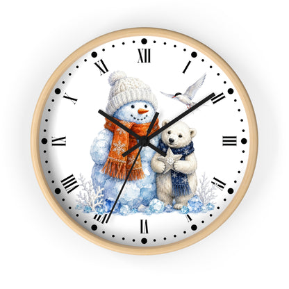 A round wall clock with a light wood frame and a white face featuring a winter illustration of a snowman in a beige knit hat and orange scarf next to a white bear in a blue sweater, with black Roman numerals and hands on a white background.