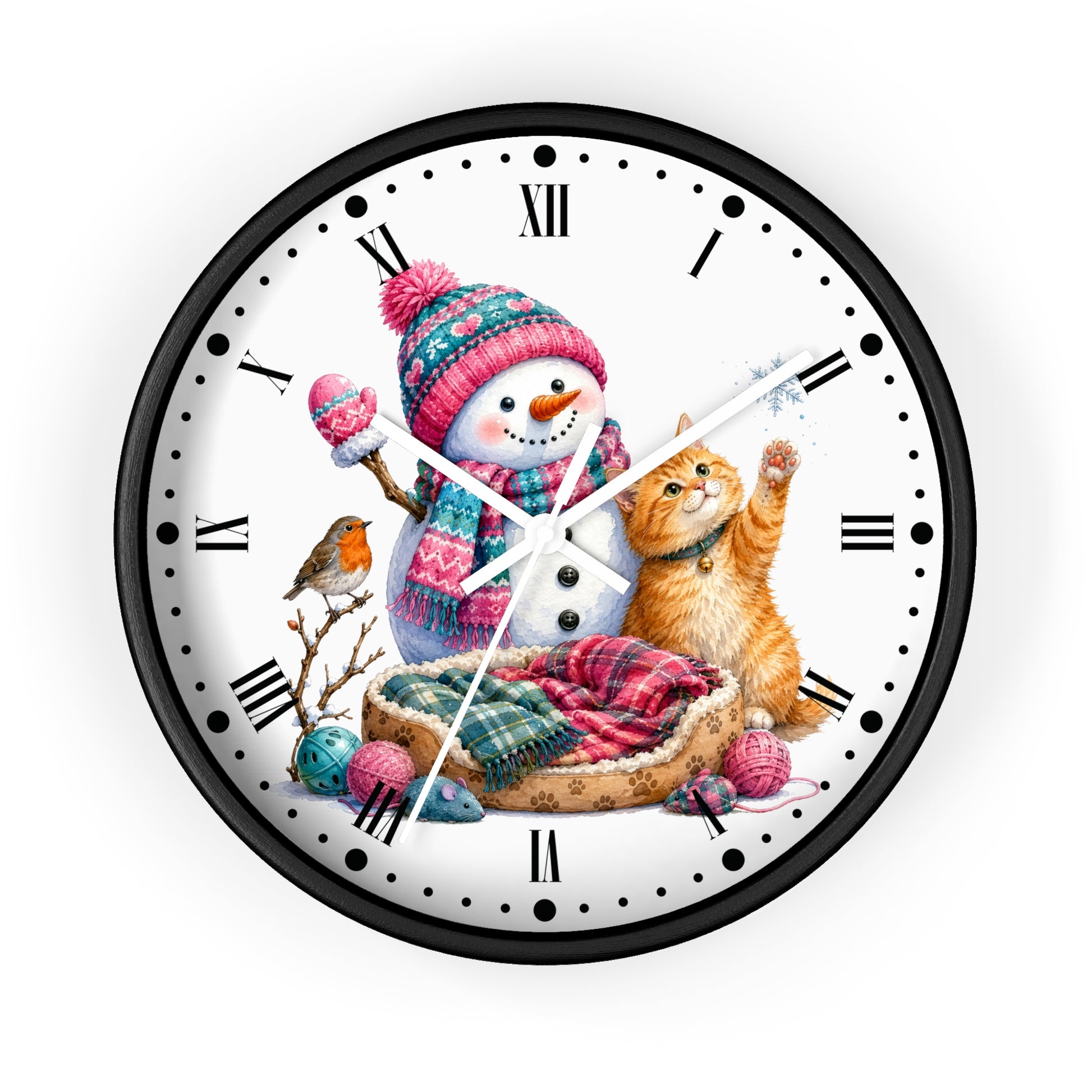 A round wall clock with a black frame and a white face featuring a winter illustration of a snowman in a pink and blue knit hat and scarf, an orange tabby cat, a small bird, and a plaid blanket.