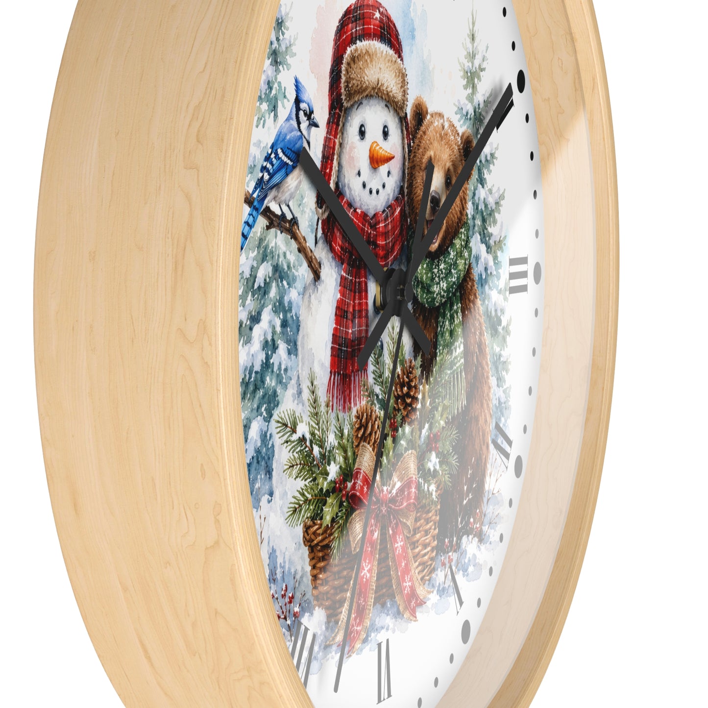 A round wall clock with a light natural wood frame and a festive winter illustration on the dial, featuring a snowman in a red plaid scarf, a brown bear, pinecones, evergreen branches, and a blue jay on a white background.