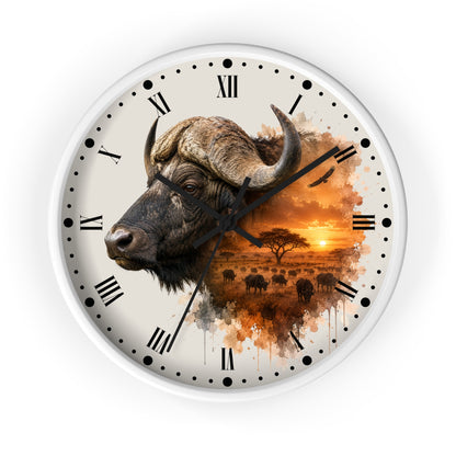 A round wall clock with a white frame and a printed safari design. The clock face features a watercolor-style buffalo head on the left, black Roman numerals and hour markers, and a warm sunset savanna scene with a tree and birds on the right.