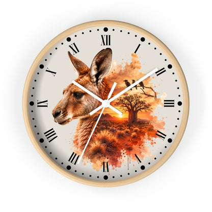 A round wall clock with a light wood frame and a printed dial featuring a kangaroo head, a tree silhouette, birds, and an orange sunset scene. The clock has black Roman numerals, black dot hour markers, and white hands, shown against a plain white background.