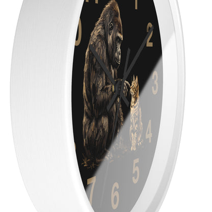 A white round wall clock with a black face featuring an illustration of a gorilla and a cat, with gold-colored numbers.