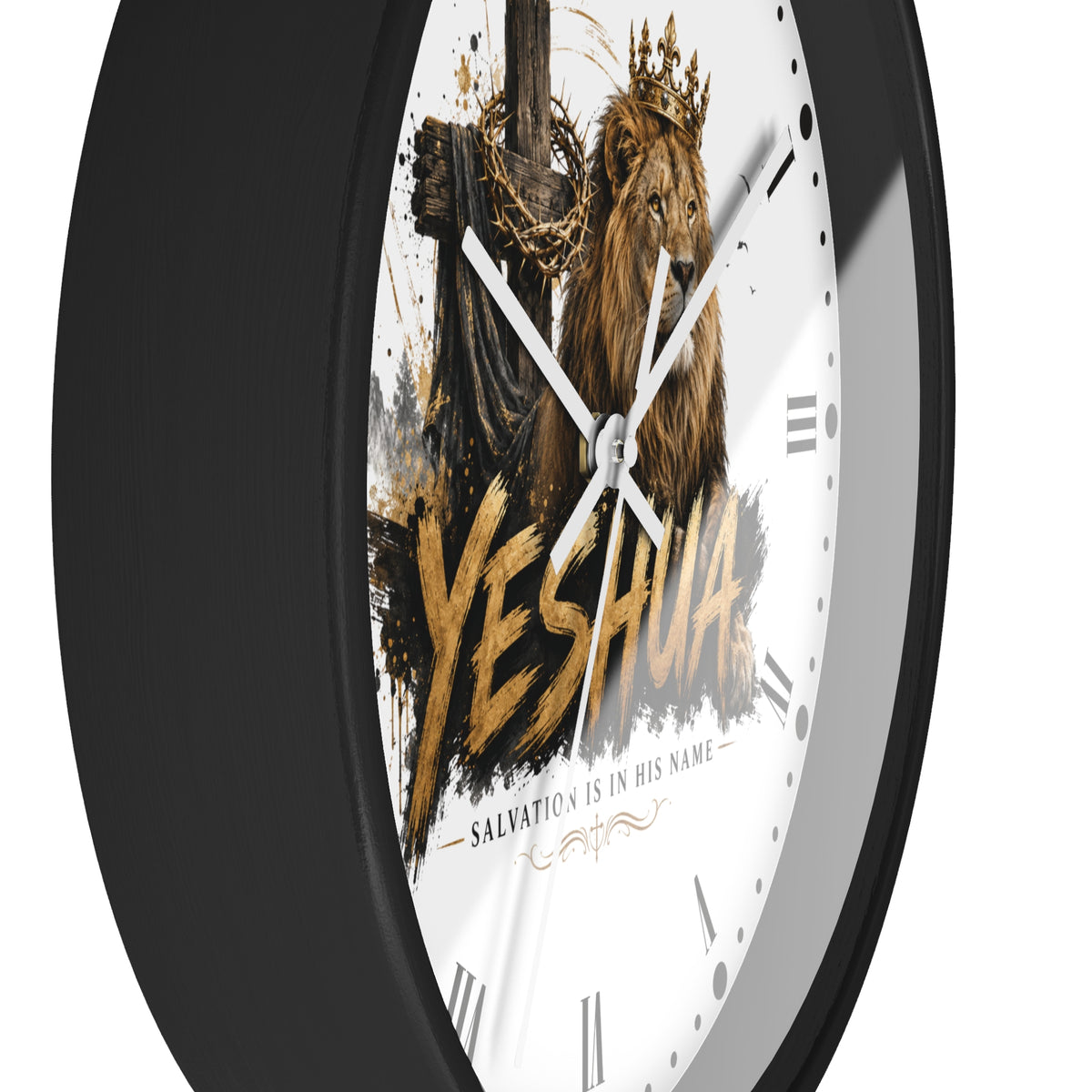 A round wall clock with a black frame and a white face featuring a crowned lion, a cross, and the word “YESHUA” in large gold lettering. The clock is shown at an angle against a plain white background.