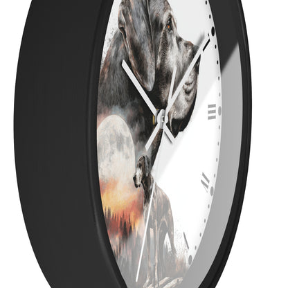 A round wall clock with a black frame and a white face featuring a photographic collage of a gray dog, a wolf, a full moon, and an orange sunset landscape. The clock is shown at an angle against a plain white background.