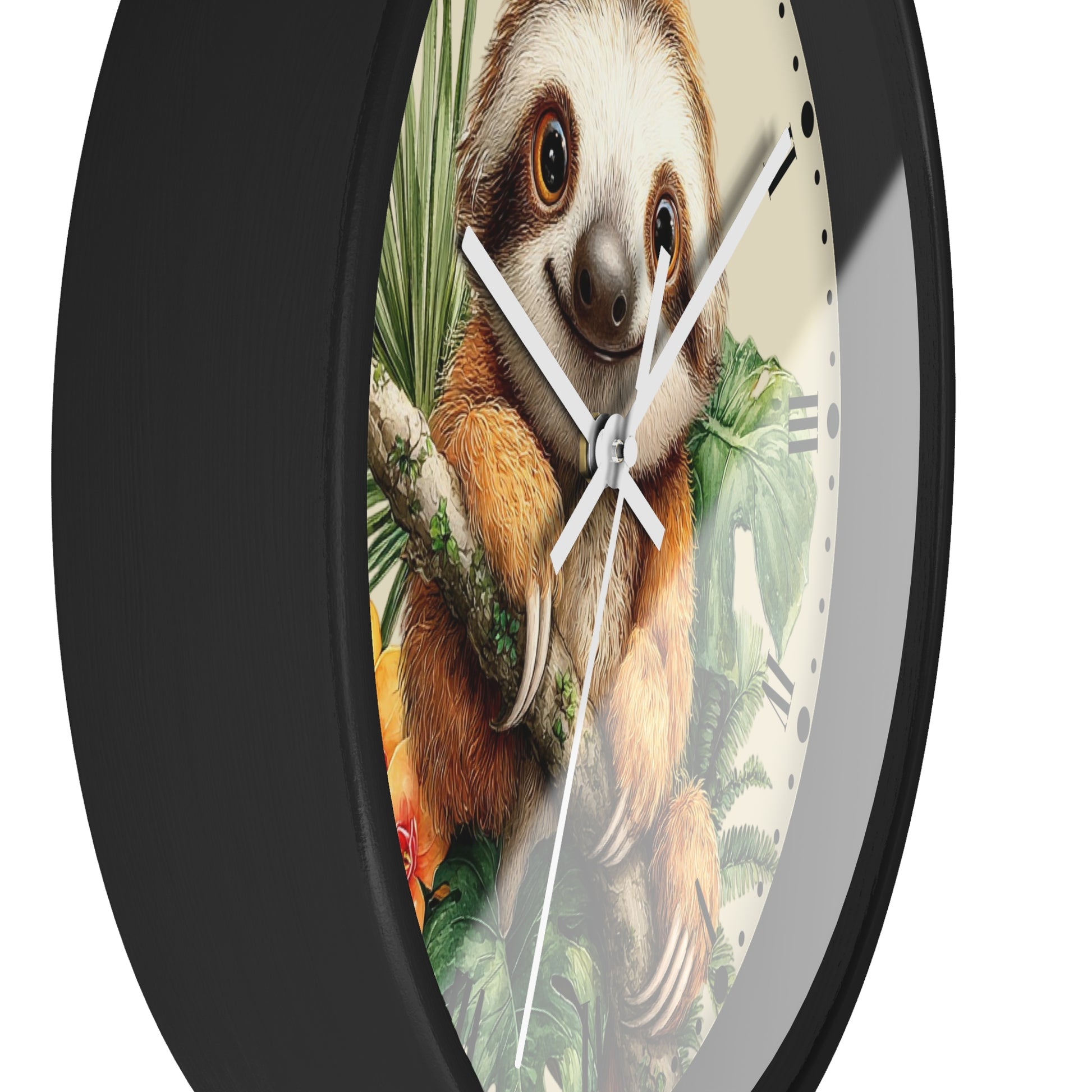 A round wall clock with a black frame and a printed illustration of a sloth hanging from a branch among tropical leaves on the clock face.