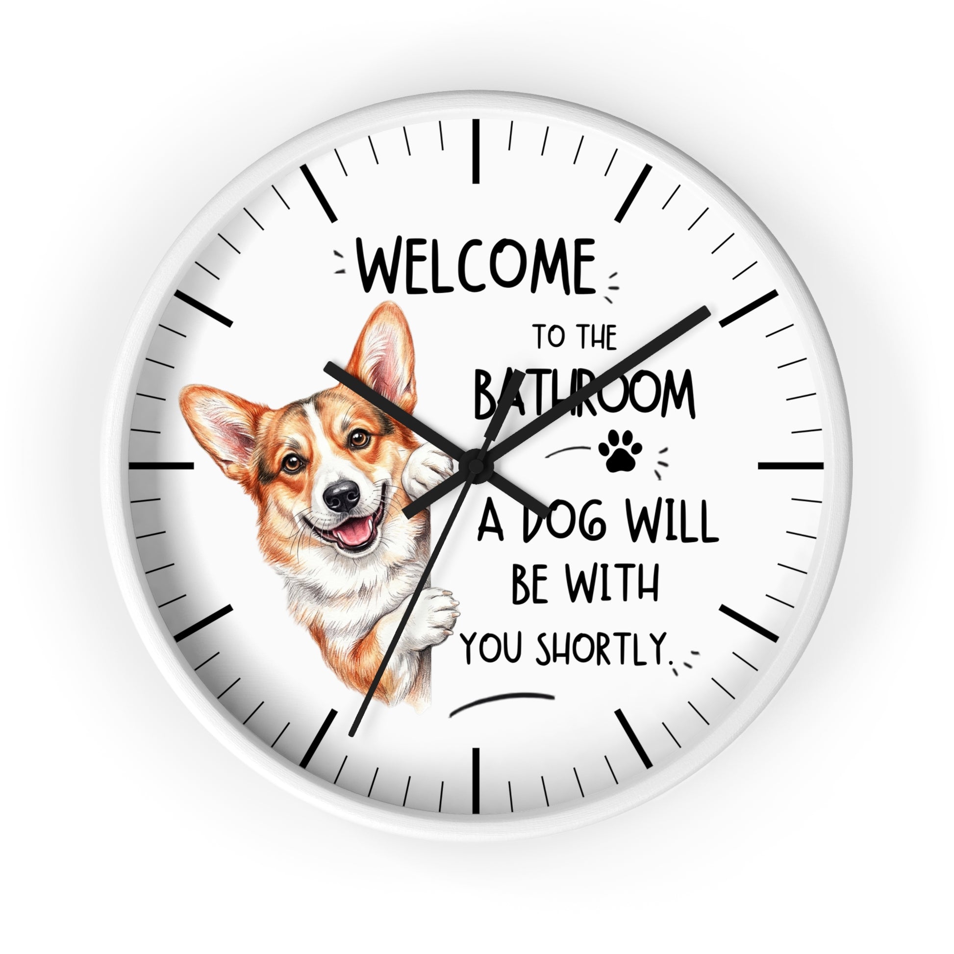 A round white wall clock with black hands and hour markers, featuring a printed illustration of a corgi dog and the text 'WELCOME TO THE BATHROOM A DOG WILL BE WITH YOU SHORTLY.' on a clean white background.