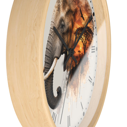 Round wall clock with a light natural wood frame and a white clock face featuring a large elephant and a warm sunset landscape design.