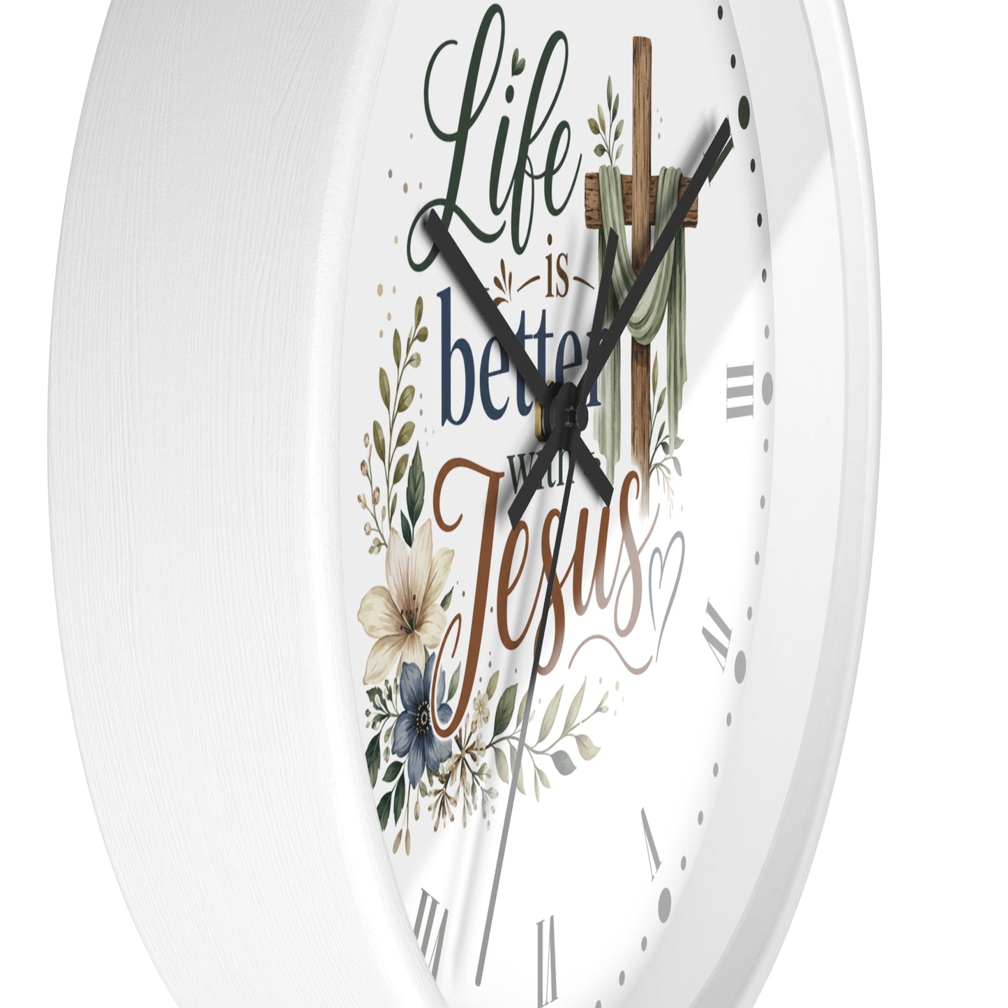 White round wall clock with a Christian-themed design featuring the text 'Life is better with Jesus' in decorative script and serif fonts, surrounded by floral and leaf illustrations, with a wooden cross graphic at the top.