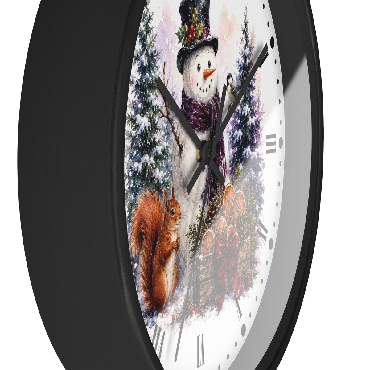 A round wall clock with a black frame and a white face featuring a winter scene with a snowman, squirrel, evergreen trees, and autumn leaves. The clock is shown at an angle against a plain white background.