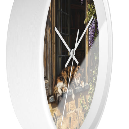 Round white wall clock with a printed scenic design featuring a calico cat by a window and purple wisteria flowers, shown against a plain white background.