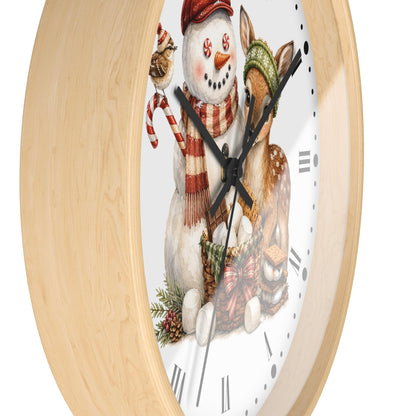 A round wall clock with a light natural wood frame and a white face featuring a festive illustration of a snowman and a deer wearing winter hats and scarves. The clock has black hands and Roman numerals.