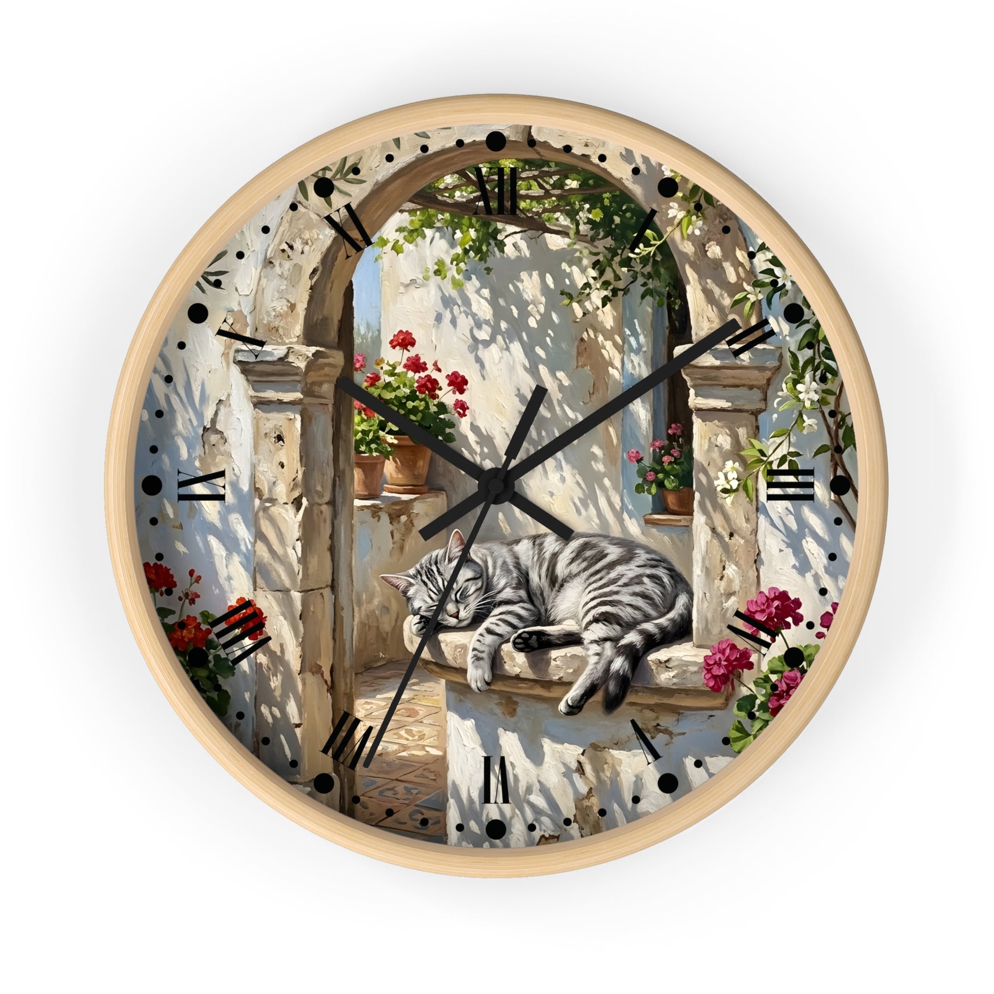 Round wall clock with a white frame and a printed scenic face showing a gray tabby cat sleeping on a stone ledge beneath an arched doorway with flowers and greenery. Roman numerals mark the hours, and the clock is photographed against a plain white background.