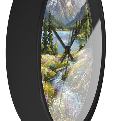 Round wall clock with a black frame and a scenic landscape print of a mountain lake, trees, and a stream, shown against a white background.