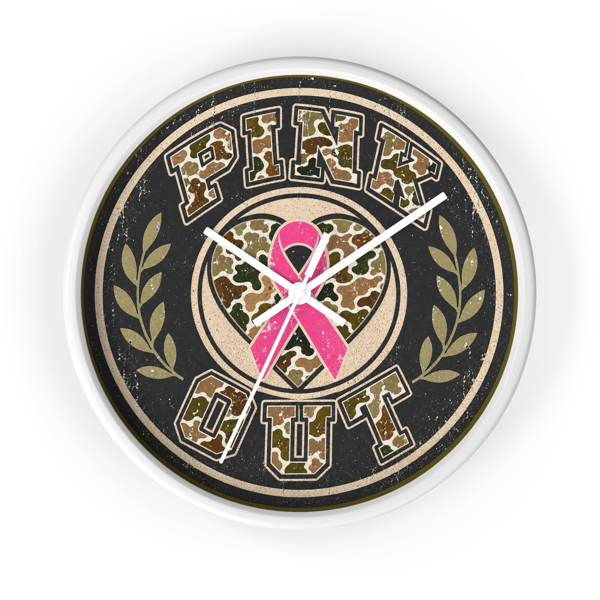A round wall clock with a distressed design featuring the words 'PINK OUT' in a camouflage pattern, a pink ribbon in the center, and olive branch motifs on either side, all set against a black background with a white clock frame.