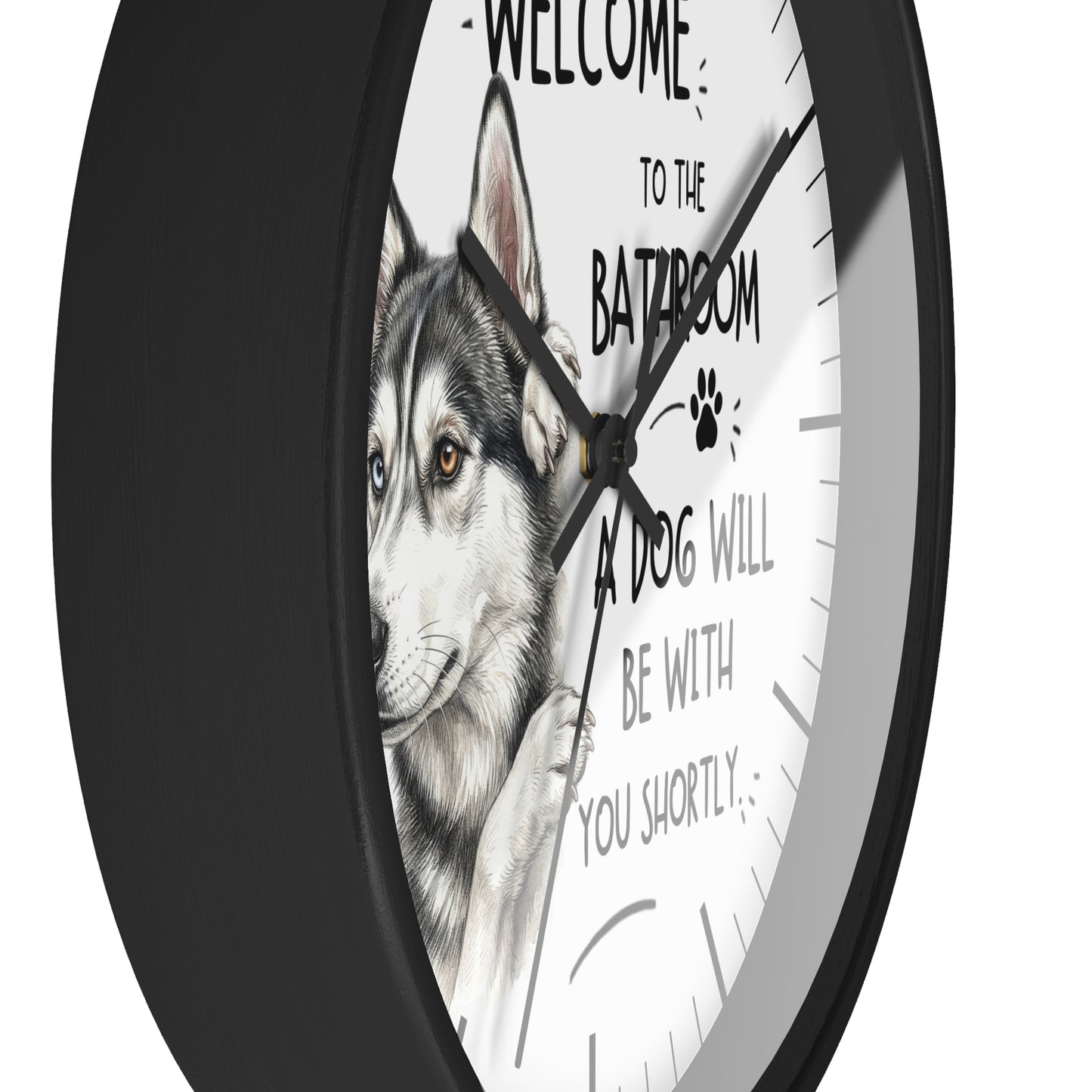 A round wall clock with a black frame and a white face featuring a husky illustration and the text 'WELCOME TO THE BATROOM A DOG WILL BE WITH YOU SHORTLY'.