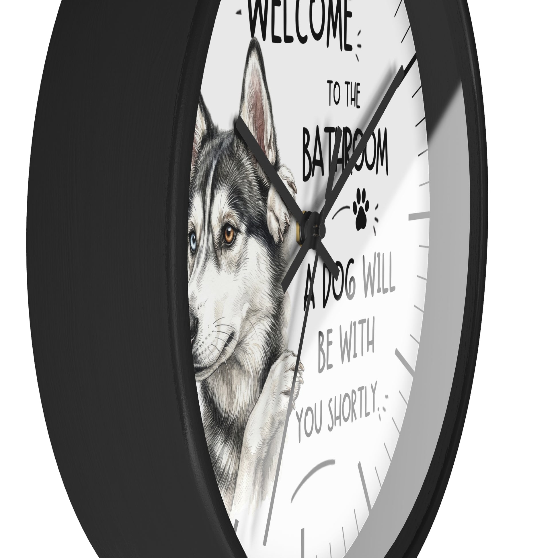 A round wall clock with a black frame and a white face featuring a husky illustration and the text 'WELCOME TO THE BATROOM A DOG WILL BE WITH YOU SHORTLY'.