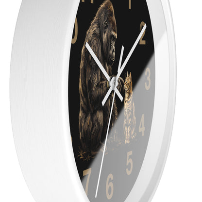 A round wall clock with a white outer frame and a dark face featuring an illustration of a gorilla and a cat, with tan Arabic numerals and white hands.
