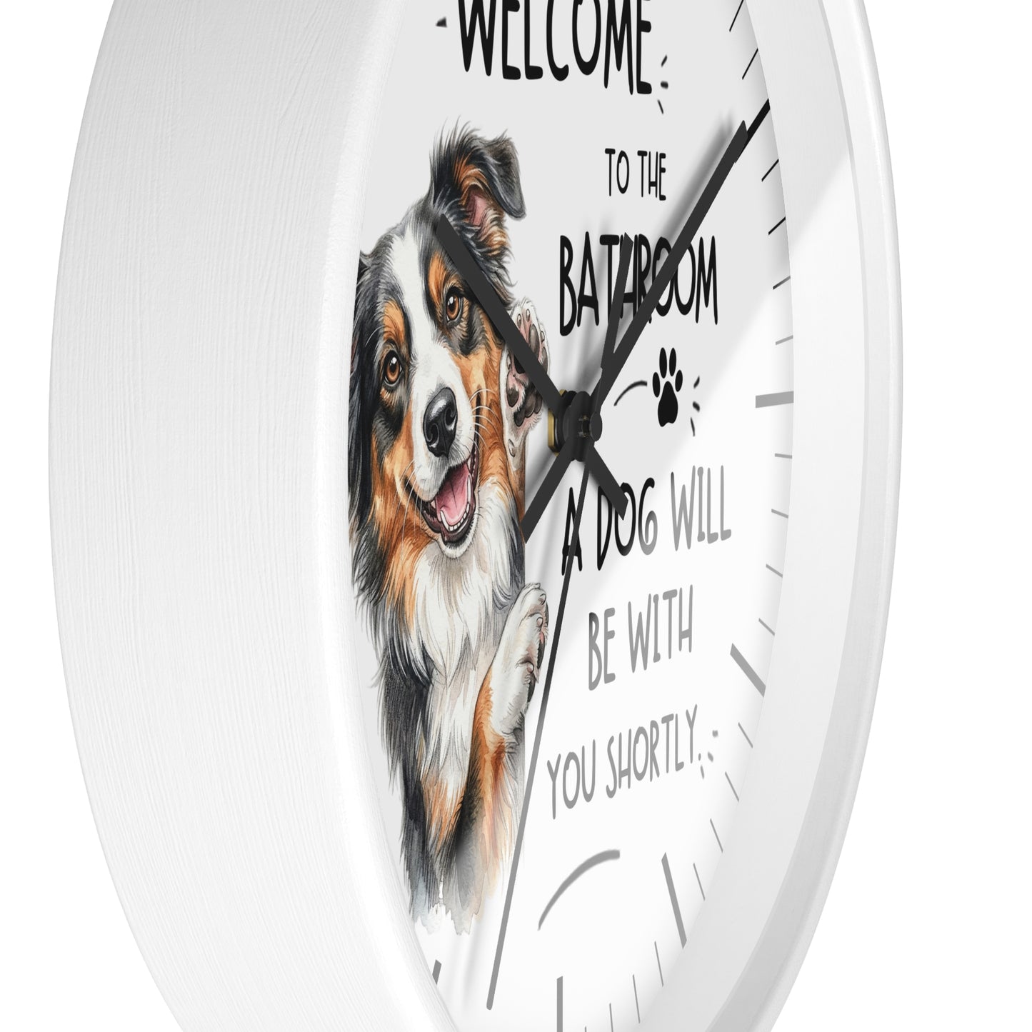 A white round wall clock with a printed illustration of a smiling dog and the text 'WELCOME TO THE BATHROOM A DOG WILL BE WITH YOU SHORTLY' on the face.