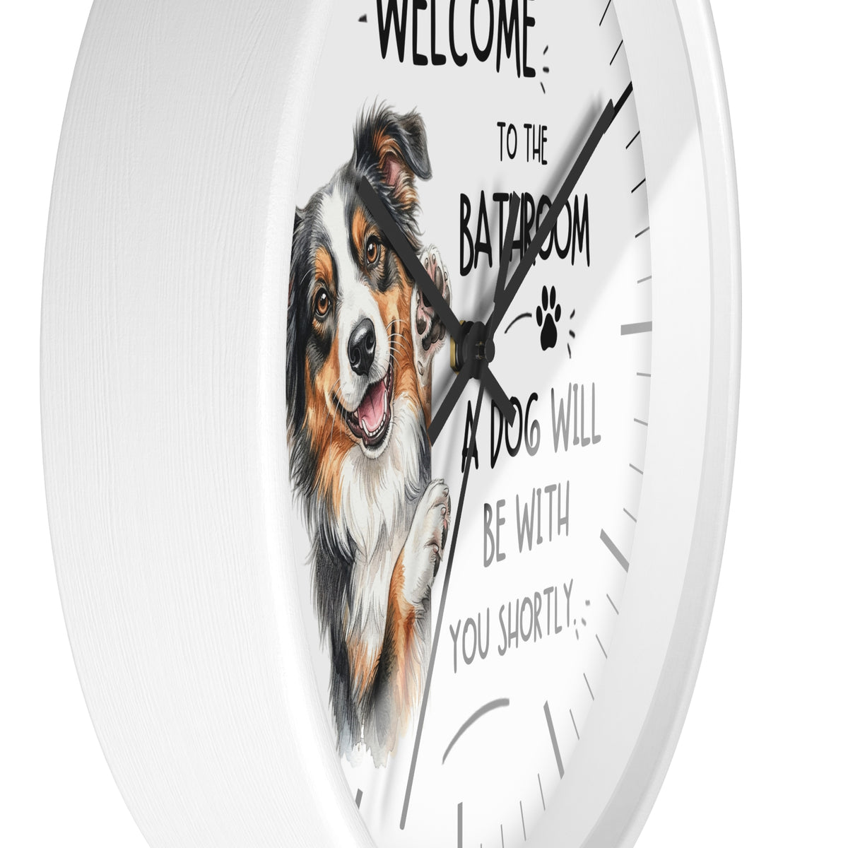A white round wall clock with a printed illustration of a smiling dog and the text 'WELCOME TO THE BATHROOM A DOG WILL BE WITH YOU SHORTLY' on the face.