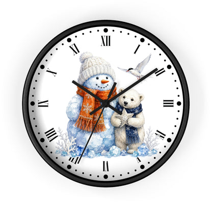 A round wall clock with a black frame and a white face featuring a winter illustration of a snowman in a beige hat and orange scarf next to a white bear in a blue sweater, with black Roman numerals and black hands.