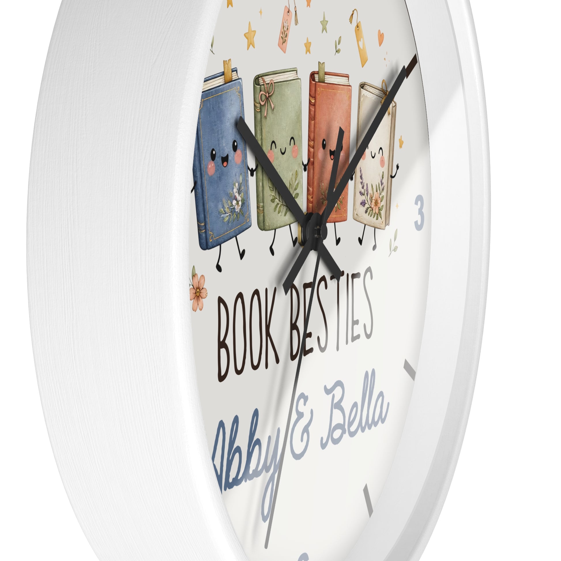 A white round wall clock with a whimsical illustration of four smiling book characters and the text 'BOOK BESTIES Abby & Bella' on the face.
