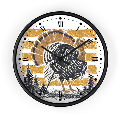 A round wall clock with a black frame and a Thanksgiving-themed illustration. The clock face features a large black and brown turkey in the center, set against a distressed gold and white striped background with black Roman numerals and black hands.