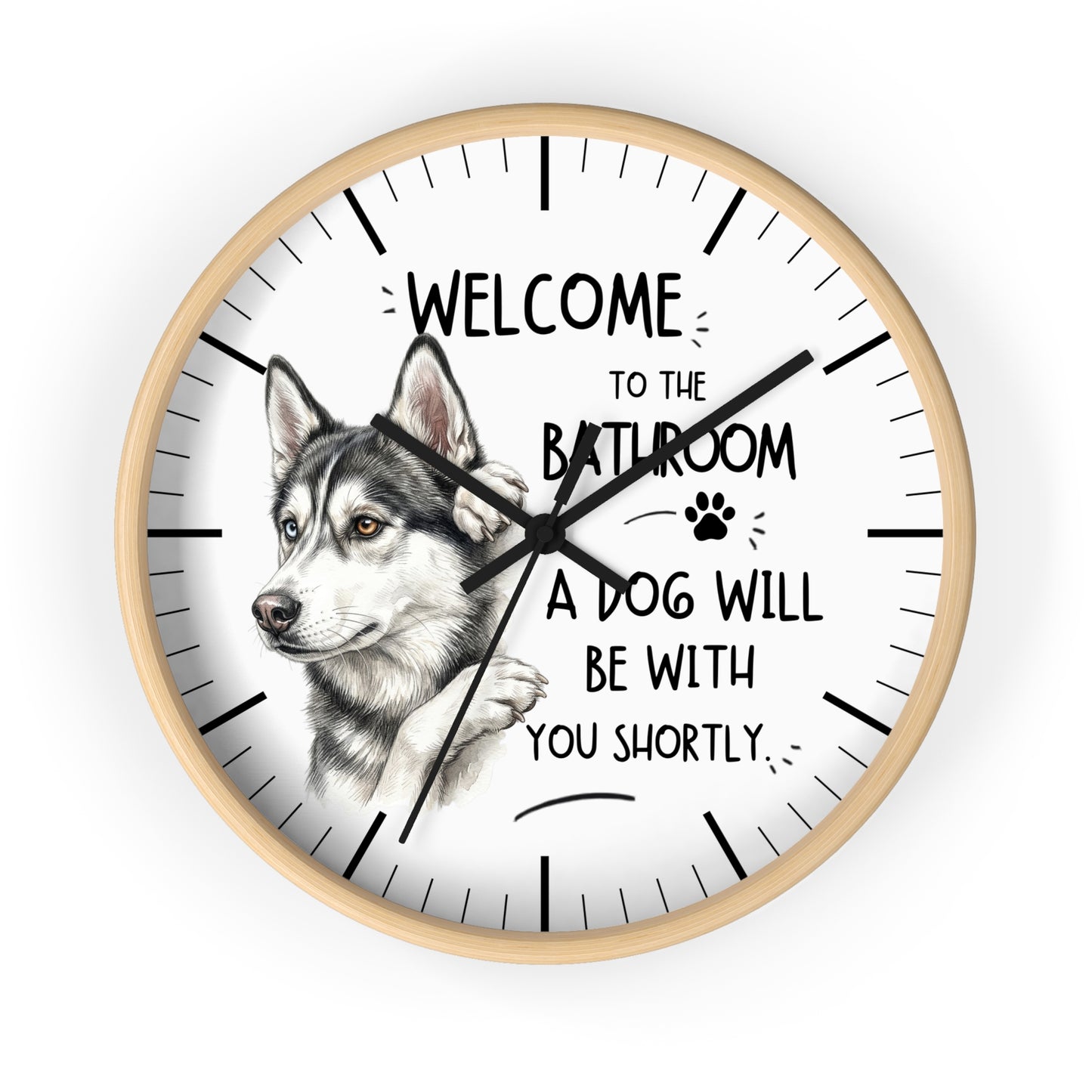 A round wall clock with a light wood frame and a white face, featuring a detailed illustration of a husky dog and the humorous text 'WELCOME TO THE BATHROOM A DOG WILL BE WITH YOU SHORTLY.'.