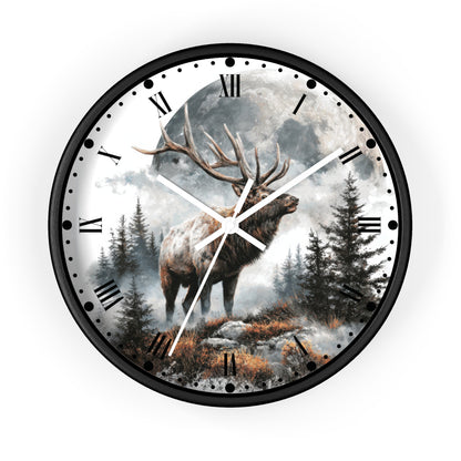 Round wall clock with a black frame and a printed forest scene featuring a large deer stag in front of a full moon. The clock face has black Roman numerals and white hands, shown on a plain white background.