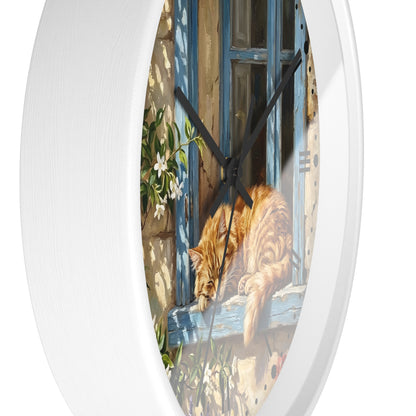 Oval wall clock with a white textured frame and a printed illustration of an orange tabby cat resting on a blue window sill.