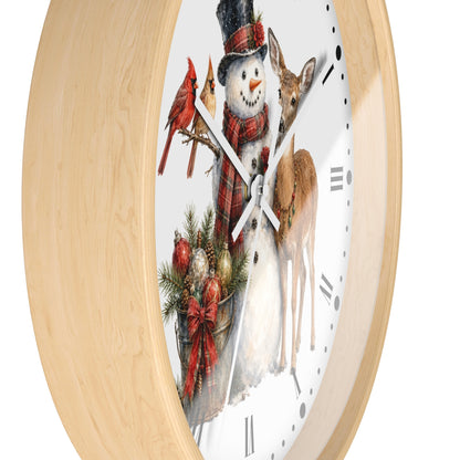A round wall clock with a light natural wood frame and a white face featuring a winter holiday illustration of a snowman, red birds, a deer, pine branches, and ornaments.