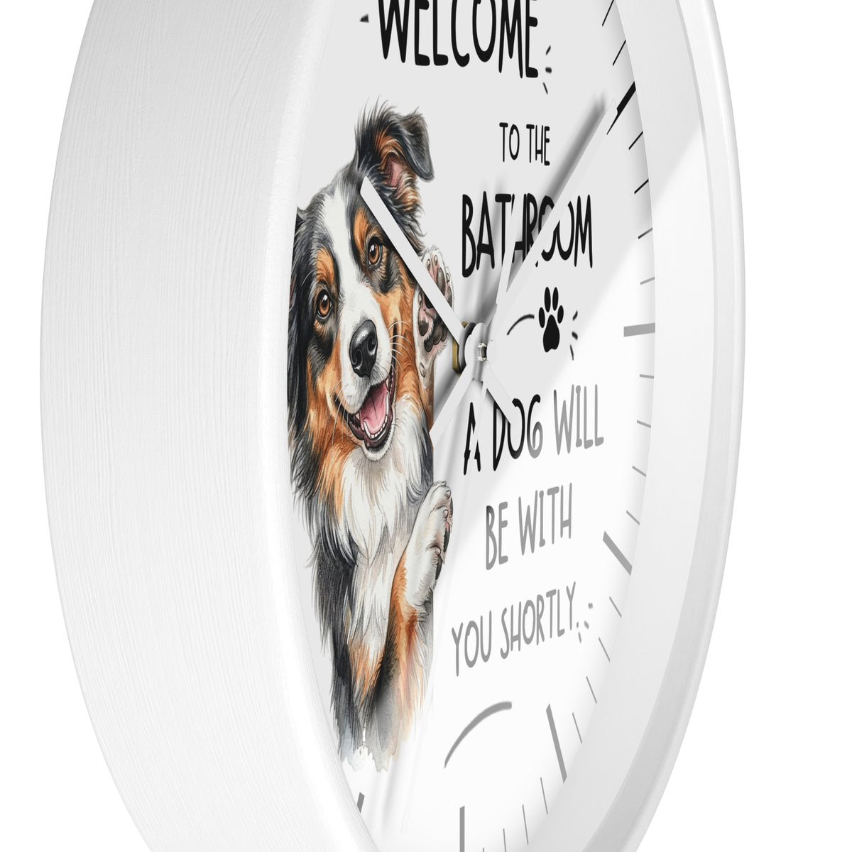 A white round wall clock with a printed illustration of a smiling dog and the text 'WELCOME TO THE BATHROOM A DOG WILL BE WITH YOU SHORTLY' on the front.