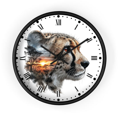 A round wall clock with a black frame and a white face featuring a large cheetah profile with a sunset landscape printed inside one of its eyes. The clock has black Roman numerals and simple black dot hour markers on a white background.