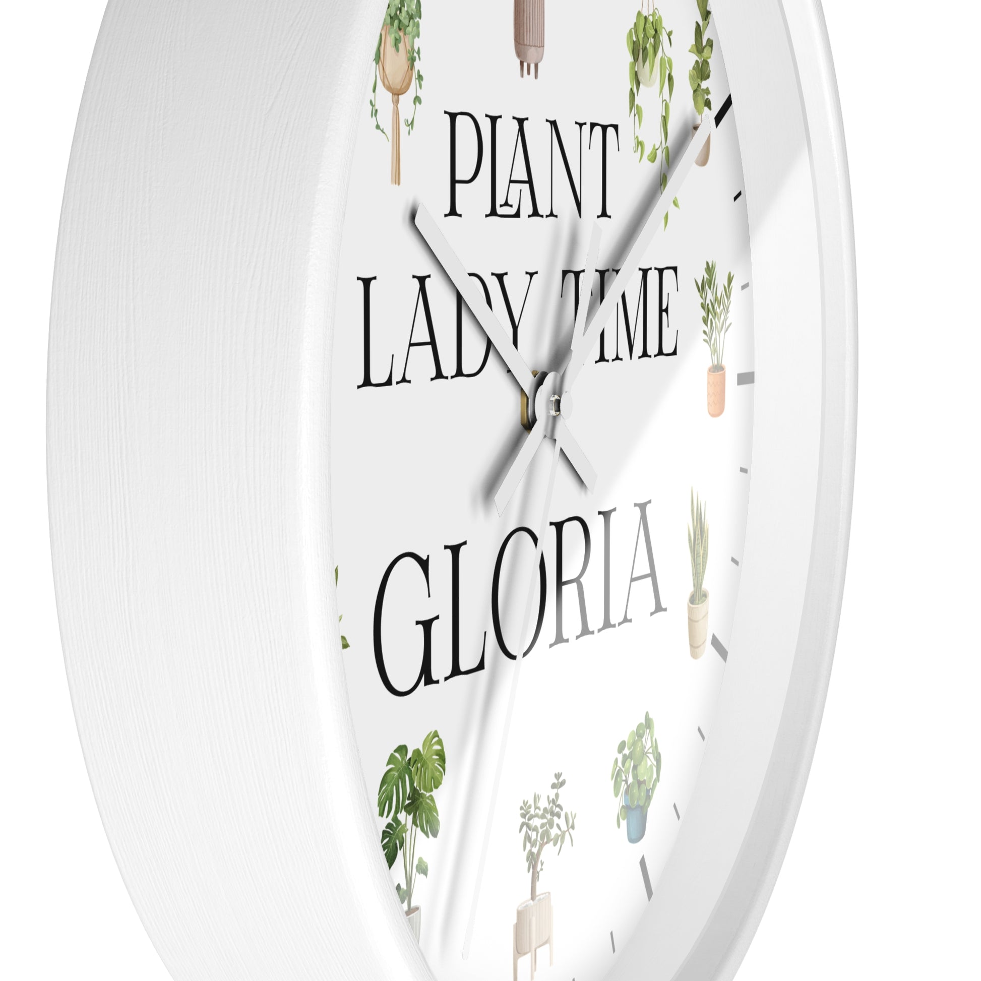 A white round wall clock with a minimalist design, featuring the text 'PLANT LADY TIME GLORIA' in black serif font and delicate illustrations of potted green plants around the dial.