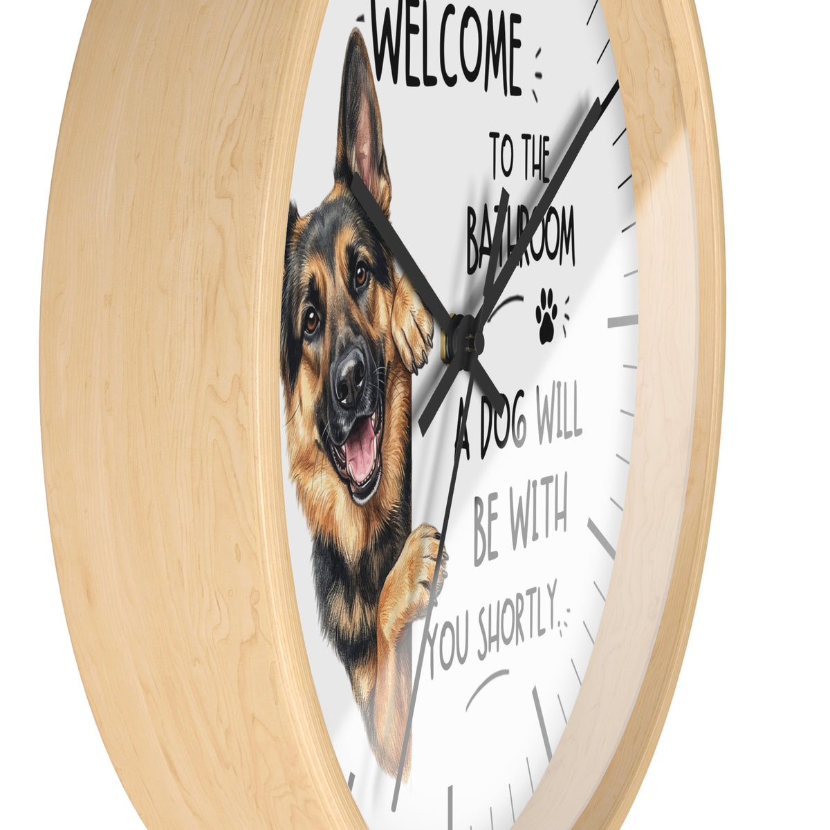 A round wall clock with a light natural wood frame and a white face featuring a German Shepherd illustration and the text 'WELCOME TO THE BATHROOM A DOG WILL BE WITH YOU SHORTLY.