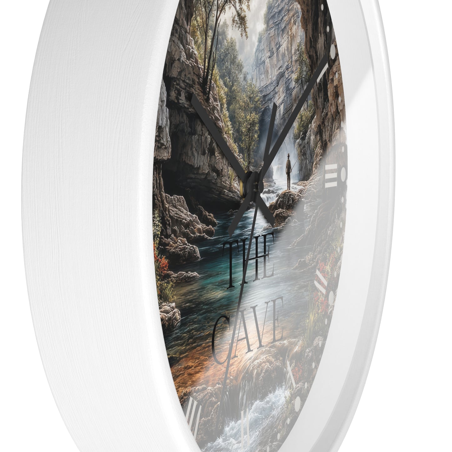 Round wall clock with a white frame and a printed scenic cave interior face, featuring a river, rocky walls, trees, and the words “THE CAVE” in large letters.