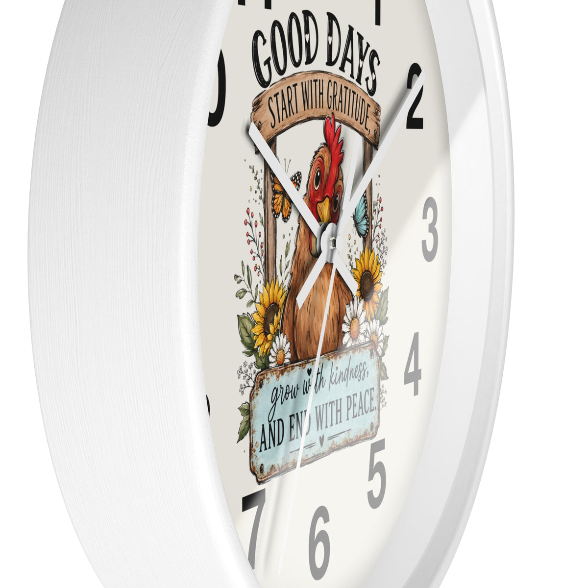 A white round wall clock with a printed graphic on the face featuring a brown rooster, sunflowers, butterflies, and the phrases “GOOD DAYS START WITH GRATITUDE” and “grow in kindness, and end with peace.”.