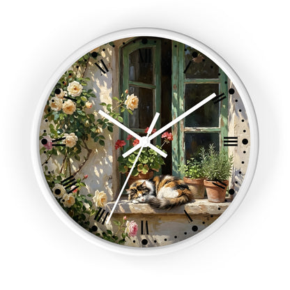 Round wall clock with a white frame and a printed scenic design featuring a cat resting on a windowsill beside climbing roses and potted plants, with white clock hands and black Roman numerals.