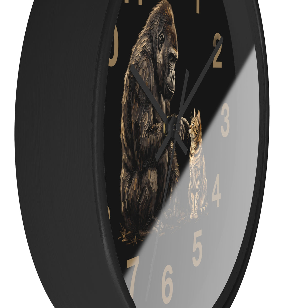 A close-up of a round wall clock with a black frame and face, featuring a detailed illustration of a gorilla and a cat in gold and brown tones, with gold Arabic numerals on a white background.