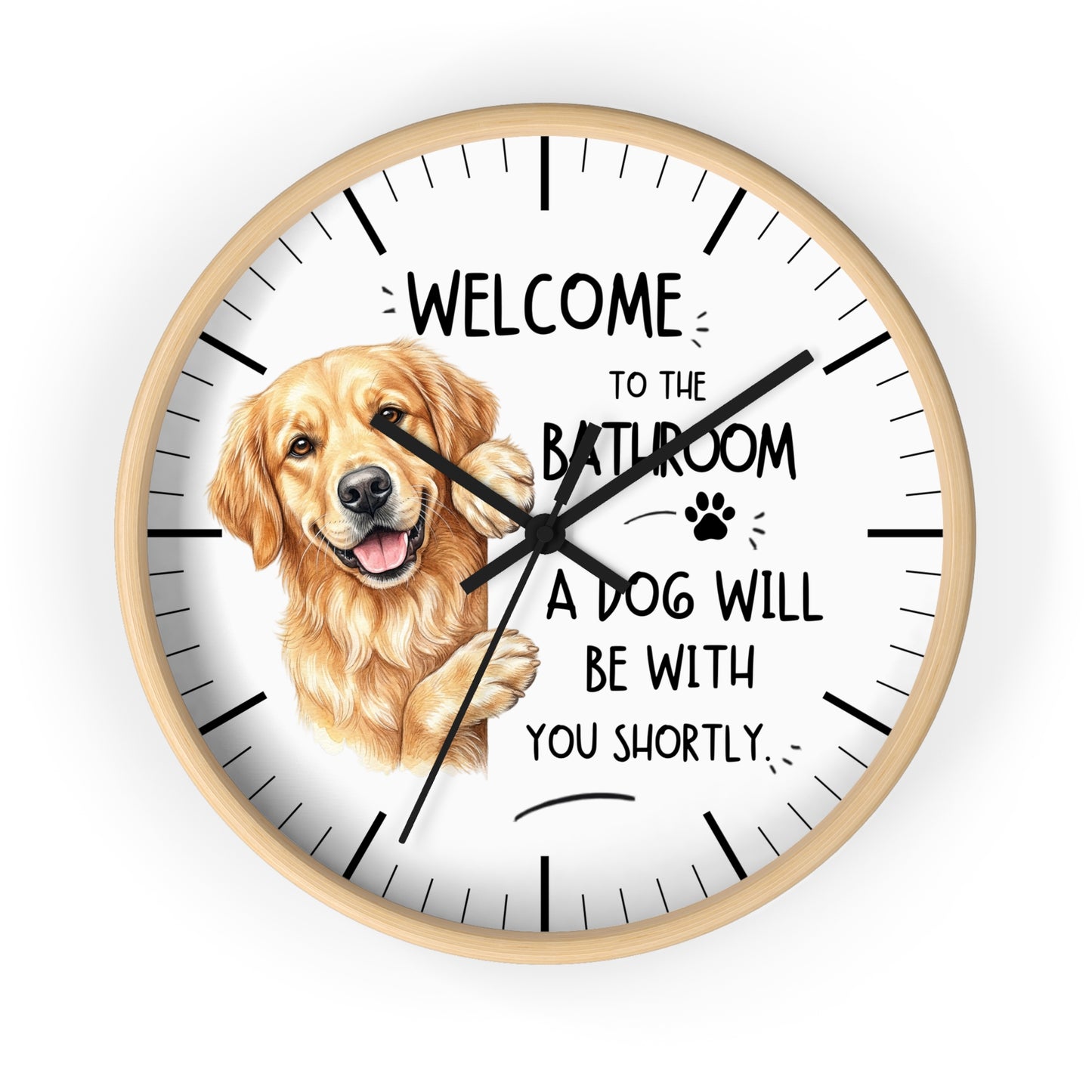 A round wall clock with a light wood frame and a white face, featuring a golden retriever illustration and the text 'WELCOME TO THE BATHROOM A DOG WILL BE WITH YOU SHORTLY.' on a plain white background.