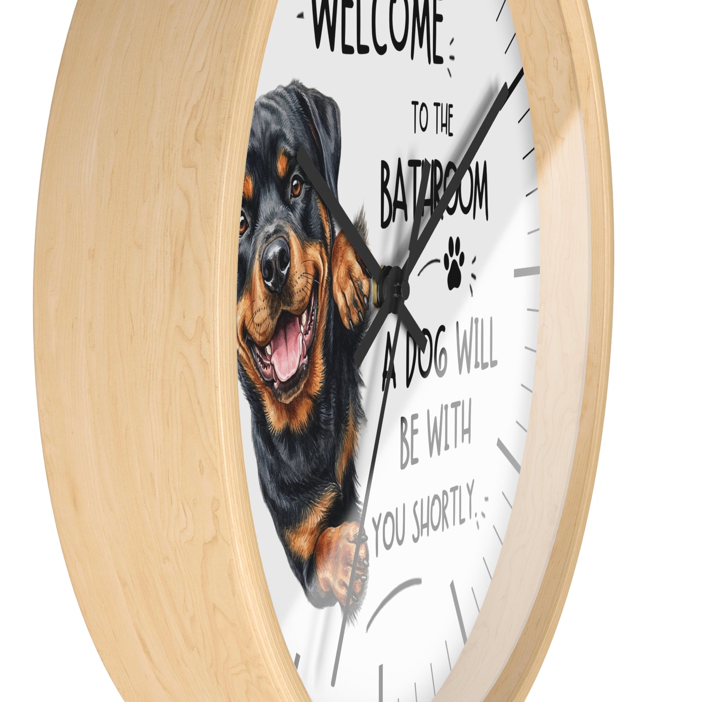 A round wall clock with a light natural wood frame and a white face, featuring a Rottweiler dog illustration and the text 'WELCOME TO THE BATROOM A DOG WILL BE WITH YOU SHORTLY'.