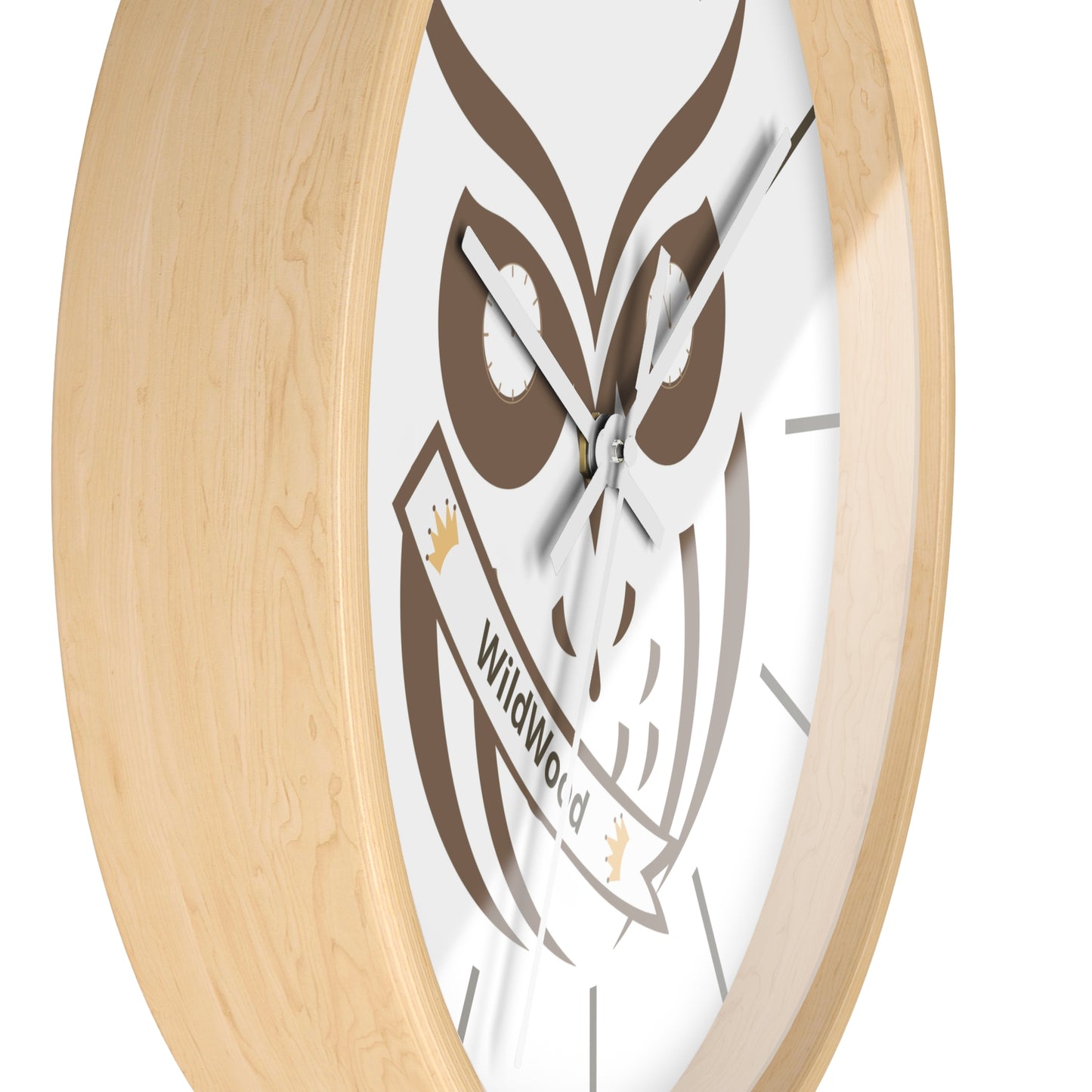 A close-up of a wall clock with a light natural wood frame and a white face featuring a brown owl illustration and a banner that reads WildWood.