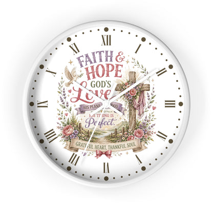 A round white wall clock with a Christian-themed floral and cross graphic on the face, featuring Roman numerals and the words 'Faith & Hope God's Love' and 'This Plan is Perfect.'.