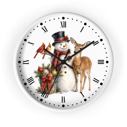 A round white wall clock with black Roman numerals and hands, featuring a festive Christmas illustration on the face with a snowman, deer, cardinals, and holiday greenery.