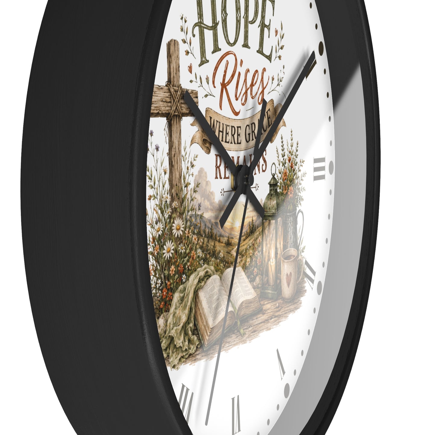 A close-up of a wall clock with a black frame and a white face featuring a rustic religious illustration with the words 'Hope Rises' and a cross.