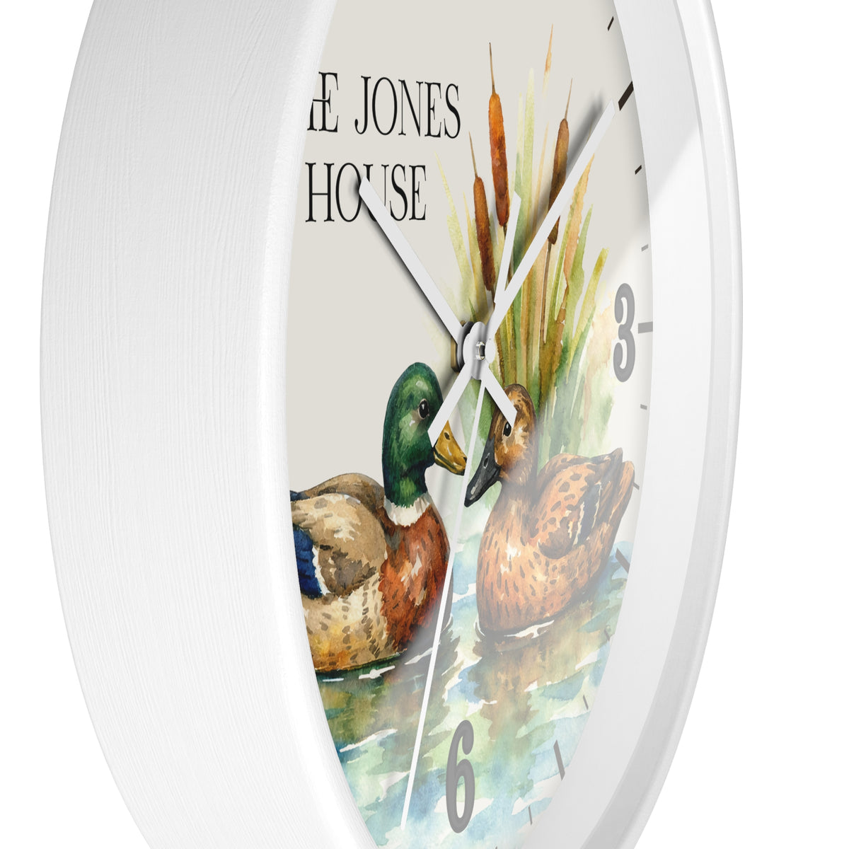 A white round wall clock featuring a watercolor-style duck illustration and the words 'THE JONES HOUSE' on the dial, shown against a plain white background.